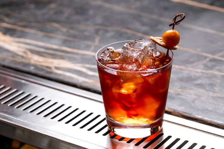 Glass of black iced tea with ice cubes and citrus garnish, served chilled as a refreshing summer tea beverage.